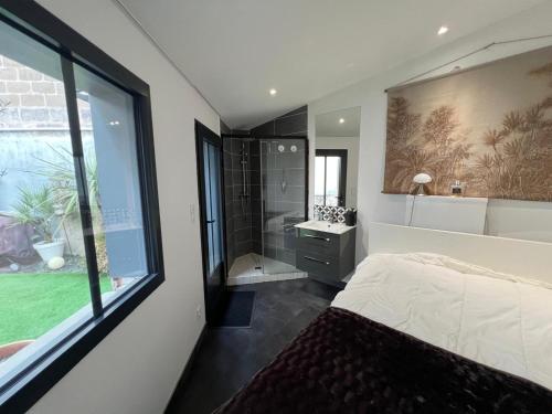 - une chambre avec un lit, une douche et une fenêtre dans l'établissement Le cocon citadin atypique et son patio, à Tours