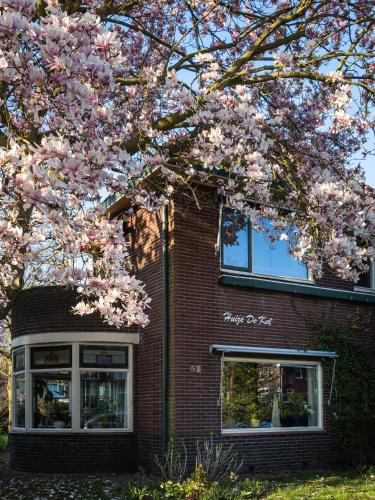 a flowering tree in front of a brick building at Huize De Kol in Holten