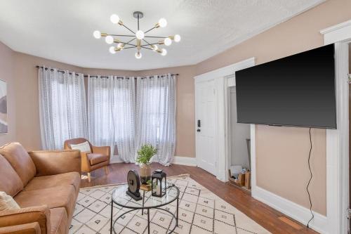 a living room with a couch and a flat screen tv at Cozy 2BR Near Destiny USA, Syracuse Uni,Zoo & Dtwn in Syracuse