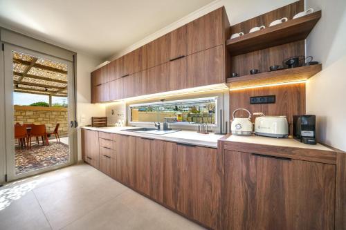 a kitchen with wooden cabinets and a sink at Casa Elegante in Pigi