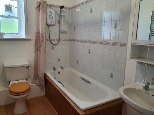 a bathroom with a tub and a toilet and a sink at Kirkwood - Real Farm Holidays & Experiences in Dalton