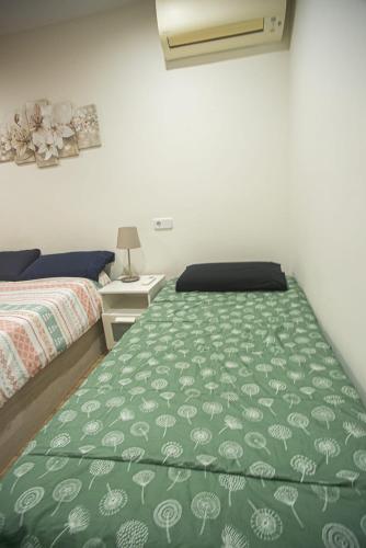 a bedroom with two beds with a green bedspread at Centro Histórico Parking con NRU y licencia turística VT-13960 in Alcalá de Henares