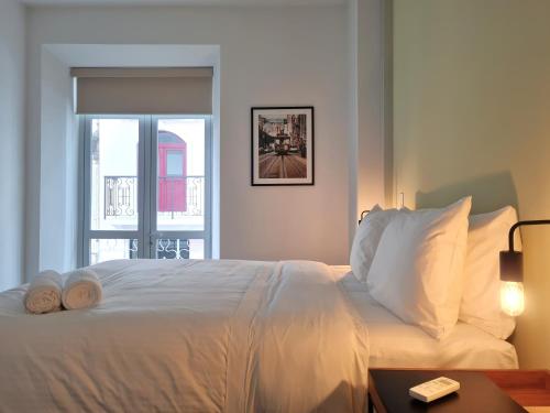 a bedroom with a white bed with a window at Lesplanade By Wynwood House in Panama City