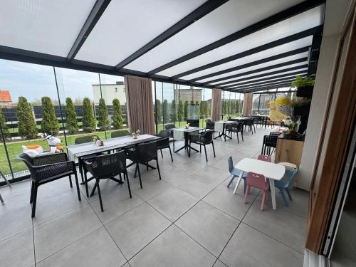 a dining room with tables and chairs and windows at KASHUBIAN Resort in Władysławowo