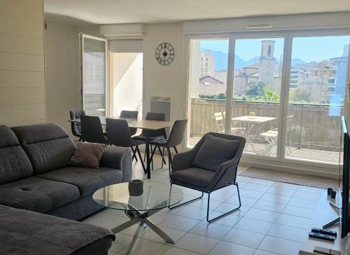 a living room with a couch and a table and chairs at Palais Omnisports, appart 4 personnes lumineux avec terrasse in Marseille
