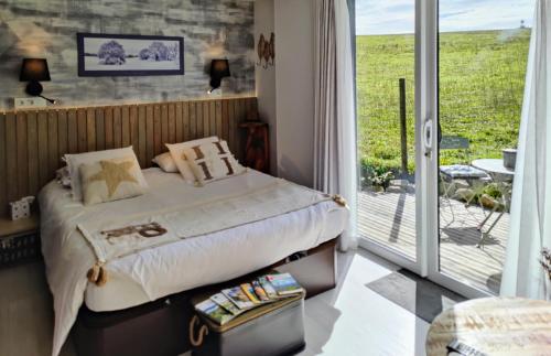 a bedroom with a bed and a sliding glass door at L'Oustalou - Suite de 19m² aux portes de l'Aubrac in Aumont-Aubrac