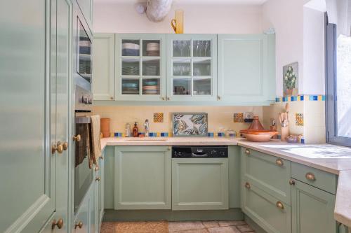 une cuisine avec des armoires vertes et un évier dans l'établissement L'Oasis, à Marseille