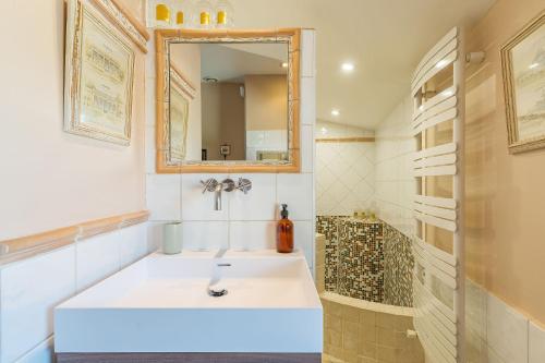 une salle de bain avec un lavabo blanc et un miroir dans l'établissement L'Oasis, à Marseille
