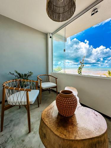 a living room with a table and a large window at Pousada D'Azul in Japaratinga