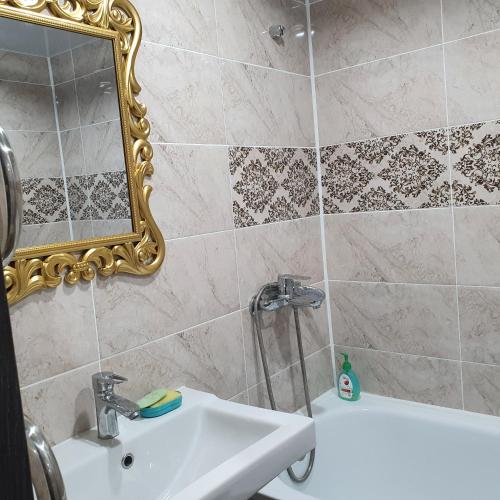 un bagno con un lavandino, uno specchio e una vasca di 2х ком квартира в Центре города ad Aqtöbe