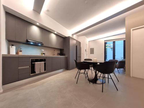 a kitchen and dining room with a table and chairs at Lesplanade By Wynwood House in Panama City