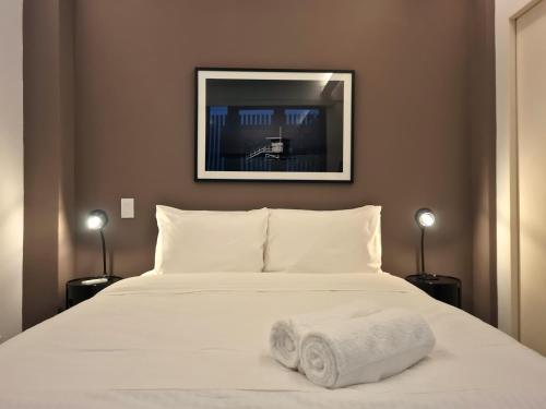 a bedroom with a white bed with two towels on it at Lesplanade By Wynwood House in Panama City
