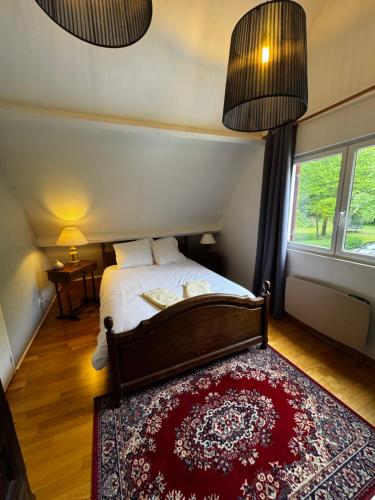 a bedroom with a bed and a red rug at L'Etincelle villa 14 pers, piscine jacuzzi, sauna in Saint-Martin-des-Champs