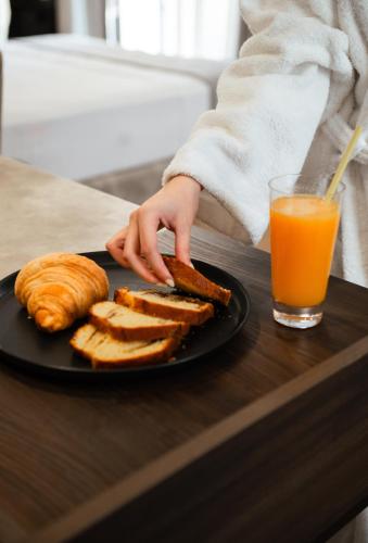 a person with a plate of toast and a glass of orange juice at JOST Caravel in Vlorë