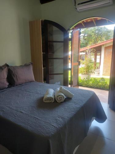 two towels sitting on a bed in a room at Apart Hotel Guaiuba in Guarujá