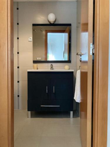 a bathroom with a black sink and a mirror at APARTAMENTO CALA-NIU in Alcossebre