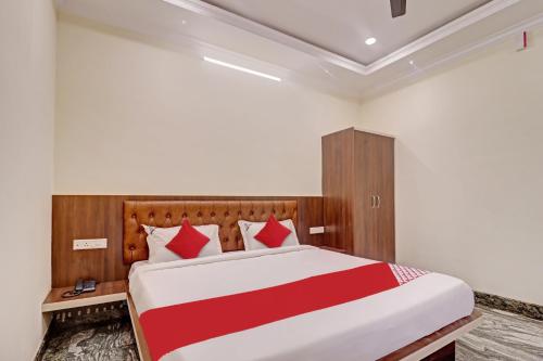 1 dormitorio con 1 cama grande con sábanas rojas y blancas en Super Collection O Ashraya Paradise, en Bangalore