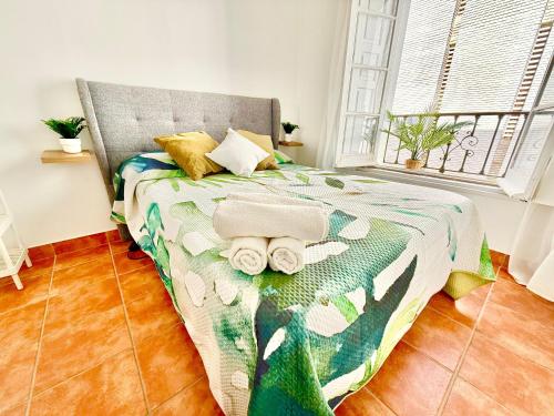 a bedroom with a bed with a green comforter at Centro apartamento 2-B in Huelva