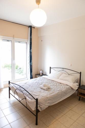 a bed in a bedroom with a large window at Airport city center 2 in Spata