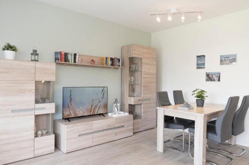 a living room with a television and a table with chairs at Seestern in Grömitz