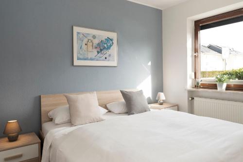 a bedroom with a white bed and a window at Seestern in Grömitz