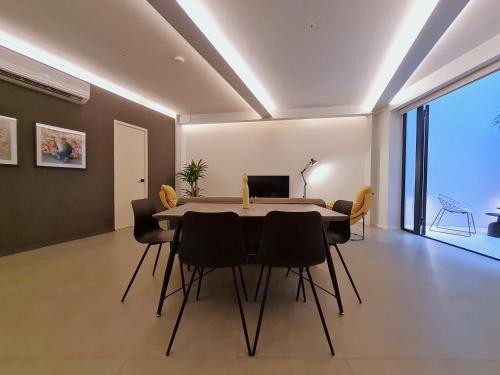 a dining room with a table and black chairs at Lesplanade By Wynwood House in Panama City