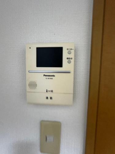 a microwave on the wall of a room at Stella 202 エアコン付 無料WiFi Netflix in Sapporo