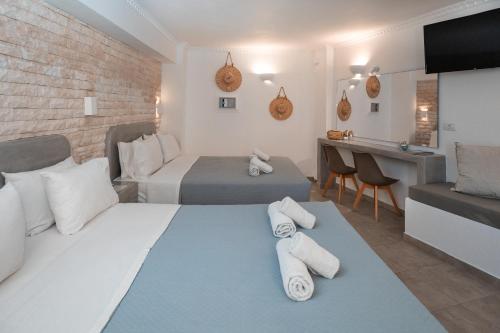 Pokój hotelowy z 2 łóżkami i biurkiem w obiekcie Perissa Bay w mieście Perissa
