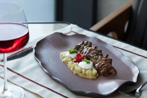 a plate of food on a table with a glass of wine at Four Points by Sheraton Istanbul Pendik in Istanbul