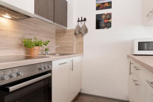 a kitchen with a sink and a stove at Schützenweg 6 Strandhafer in Kellenhusen