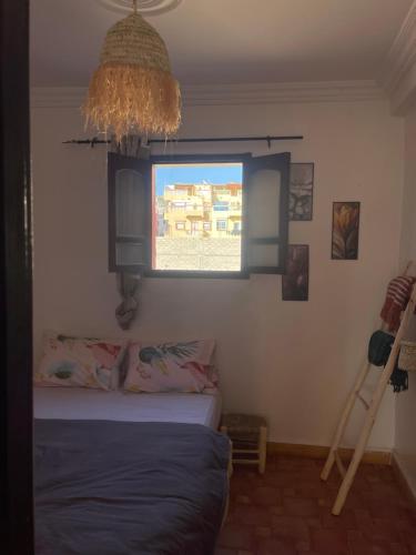 a bedroom with a bed and a window at Inner Wave Morocco - Boutique Surf Yoga House in Tamraght Ouzdar