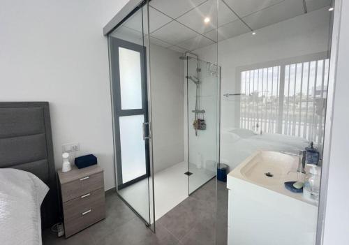 a bathroom with a glass shower and a sink at Villa El Loto Blanco in Dolores
