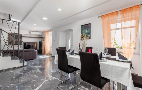 a dining room with a table and black chairs at Kameni biser in Jurdani