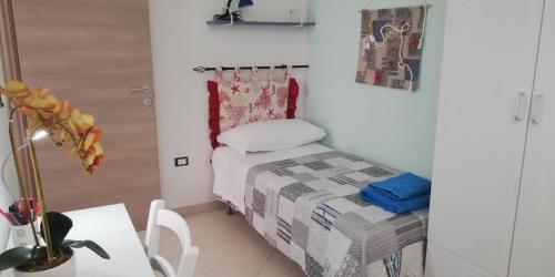 een kleine kamer met een klein bed en een tafel bij Melograno2 in Torre San Giovanni Ugento