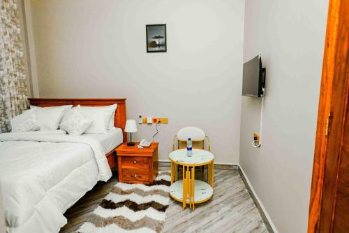 a bedroom with a bed and a table with a night stand at Joy Inn Hotel in Dar es Salaam