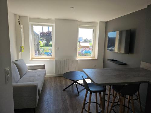 - un salon avec un canapé, une table et 2 fenêtres dans l'établissement Appartement Djo&Juh 3, à Granville