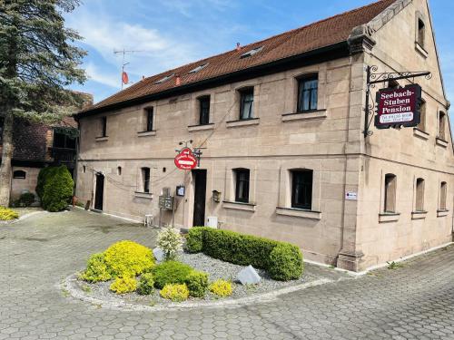 a large stone building with a sign on it at Seebachstuben - gemütliche Mehrzimmerapartments in Dechsendorf in Erlangen