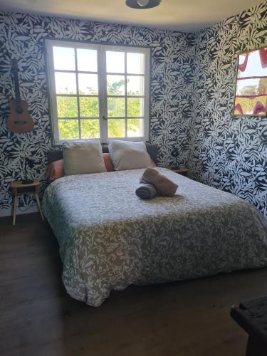 - une chambre dotée d'un lit avec du papier peint bleu et blanc dans l'établissement Petit cocon proche Rennes, à La Celle-sous-Gouzon