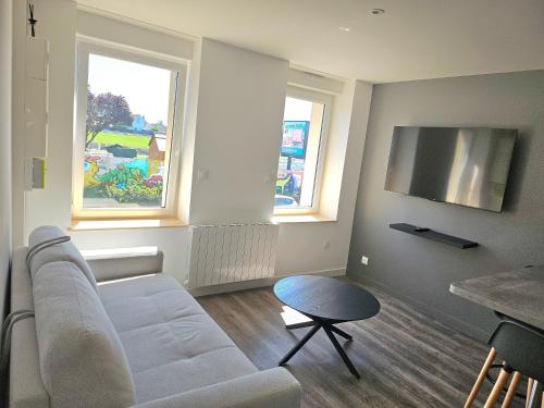 - un salon avec un canapé blanc et 2 fenêtres dans l'établissement Appartement Djo&Juh 3, à Granville