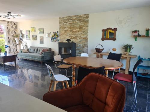 un salon avec une table, des chaises et un canapé dans l'établissement Petit cocon proche Rennes, à La Celle-sous-Gouzon