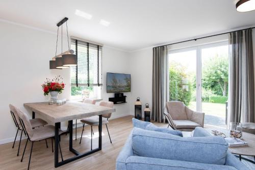 a living room with a table and a blue couch at Kellenhüs in Kellenhusen