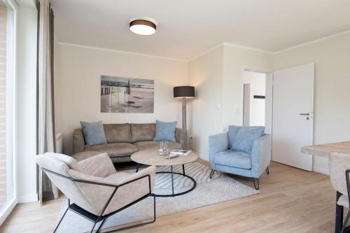 a living room with a couch and a table and chairs at Kellenhüs in Kellenhusen