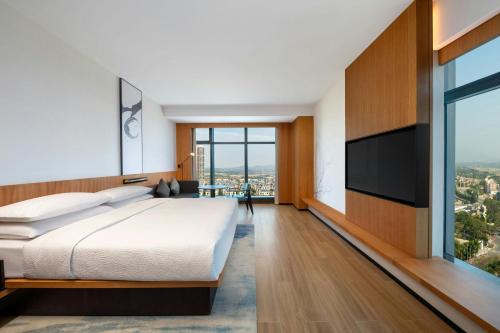 a bedroom with a large bed and a flat screen tv at Fairfield by Marriott Taishan in Jiangmen