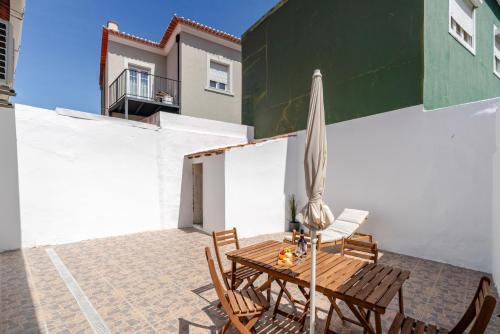 a patio with a table and an umbrella and chairs at HostWise - Traditional House with Terrace in Porto