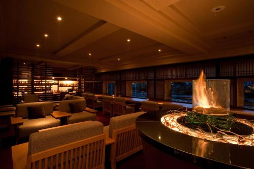 a restaurant with a fireplace in the middle of the room at Lake Shikotsu Tsuruga Resort Spa Mizu no Uta in Chitose