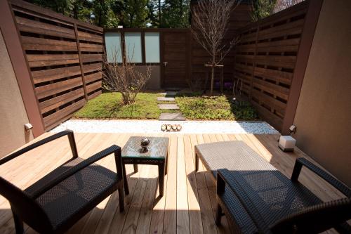 a patio with two chairs and a table on a deck at Lake Shikotsu Tsuruga Resort Spa Mizu no Uta in Chitose