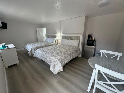 a bedroom with two beds and a table and a bed sidx sidx sidx at Sea Dell Motel - Marathon in Marathon