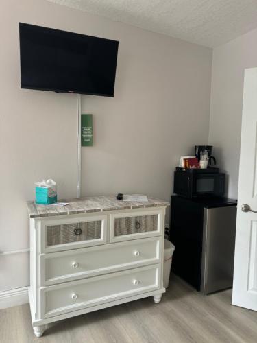 a white dresser with a television on top of it at Sea Dell Motel - Marathon in Marathon