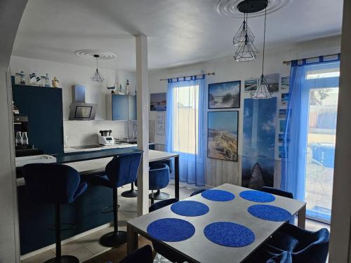 une cuisine avec une table et des chaises dans une pièce dans l'établissement appartement terrasses poulpatre, à Crozon
