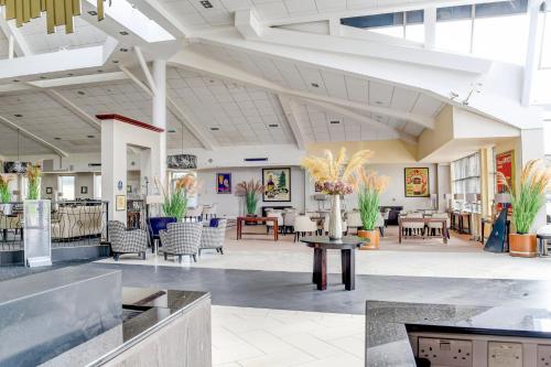 a lobby with tables and chairs in a building at Belvilla Aberdeen Bridge of Don Exhibition Centre in Aberdeen